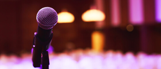 Close up of microphone on stage lighting at concert hall or conference room. copy space banner....