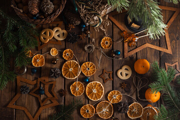 Dried slices of oranges cut into circles lie on a wooden table. New Year's Flatley