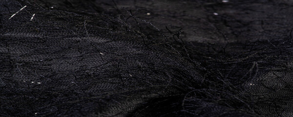 Fototapeta na wymiar Charcoal black silk fabric with sequins and yarns over the surface of the fabric. This ombre tulle in black with abstract embroidery, embellished with sequins and yarns from a European designer