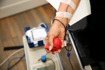 Detail with the hand of a blood donor and a plastic blood bag in a hospital - obrazy, fototapety, plakaty