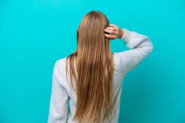 Young Russian woman isolated on blue background in back position and thinking