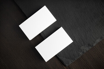 Blank white business cards on stone board. Mockup for ID. Template for graphic designers...