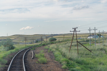 Fototapeta na wymiar railway, railroad, rail, elevated. steppe prairie veld. is a means of transportation and passengers of trucks moving on rails that are located on the rails of the Great Plains. Kazakhstan 