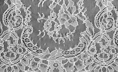 Gray-white lace on a black background. Template for wedding invitation and greeting card with lace fabric background. Filigree floral elements, ornate vintage ornament.