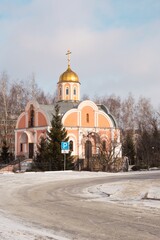 Church with golden dome and cross on sunny winter day and snowy