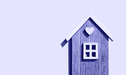Wooden house with a heart on a light background with a place for text. Flat lay. Trendy Color of...