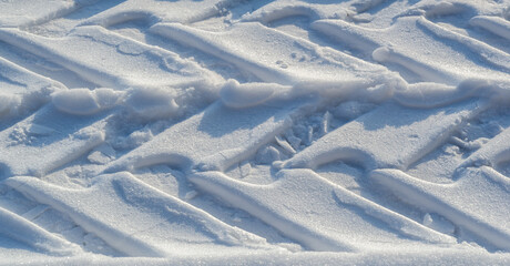 Tire tread marks. Snow covered the ground. Sunny day. Soon the warm spring sun will melt the winter...