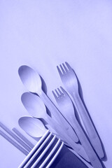 A set of disposable tableware made of bamboo. Vertical image. Trendy Color of Year 2022.
