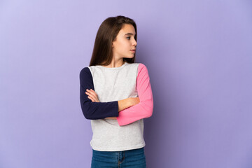 Little girl isolated on purple background keeping the arms crossed