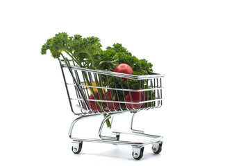 Closeup of fresh vegetables in a miniature trolley of supermarket on white background