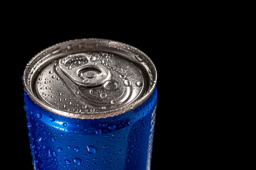 Side view of a blue aluminum can with water droplets on a black background. Close-up. A sweet soft drink.