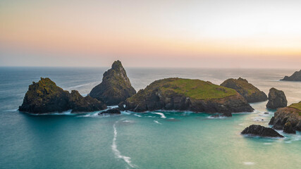 The coastline of Cornwall, England. A summers evening and the sky is glowing as the sun sets over the spectacular, rugged coastline