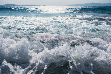 Obraz premium Splashing sea wave in front of beautiful sunset sky background. Fresh blue water.