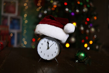 Christmas composition with an alarm clock and a Christmas tree in the background