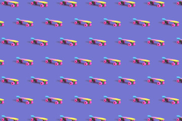 Pattern made of pastel neon rainbow colored Penny board skateboard on solid purple background....