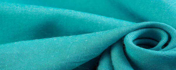 turquoise fabric, twill. Thin fabric with diagonal weaving of threads. From Latin and French, the name of the material is transla Texture, background