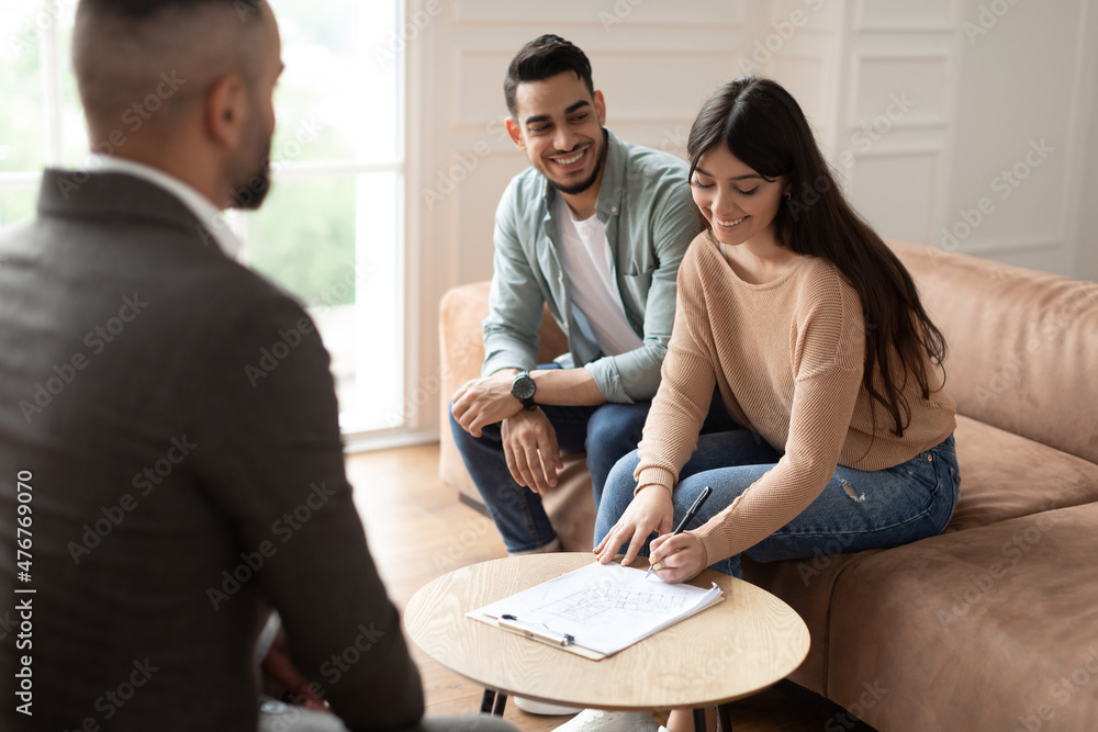 Poster real estate agent showing buyers contract, woman signing