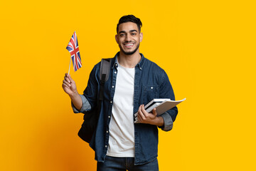 Smiling arab guy student showing flag of Great Britain