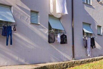 Clothes, towels and bed sheets hanging out of the window to dry (Pesaro, Italy, Europe) - 476769099
