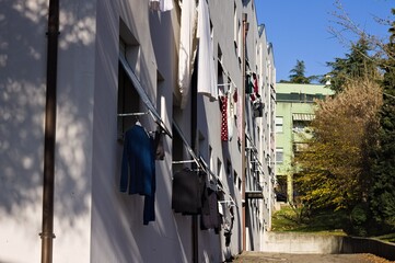 Clothes, towels and bed sheets hanging out of the window to dry (Pesaro, Italy, Europe) - 476769220