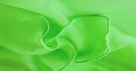 Green silk organza with wavy piping. Border around the edge of the fabric. Abstract background....