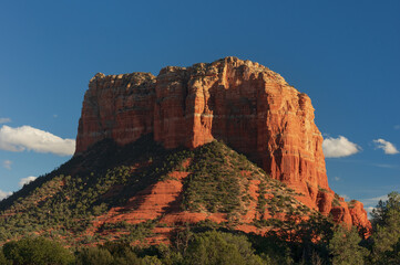 Fototapeta na wymiar Sedona, Arizona view of a red rock butte and cliff face against a blue sky.