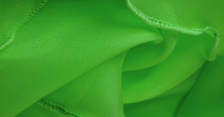 Green silk organza with wavy piping. Border around the edge of the fabric. Abstract background....