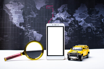 yellow car,magnifying glass,smartphone on the background of the world map