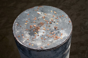A silver metal pole with money, penny's on it. Park attraction