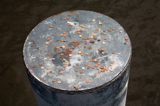 A Silver Metal Pole With Money, Penny's On It. Park Attraction