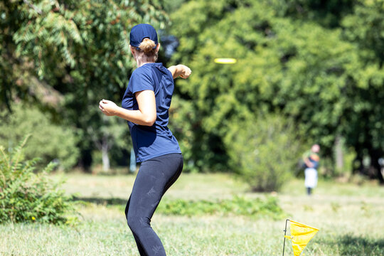 Young woman playing flying disc sport game in the park