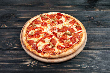 Hot tasty traditional italian pizza with salami, cheese, tomatoes greens