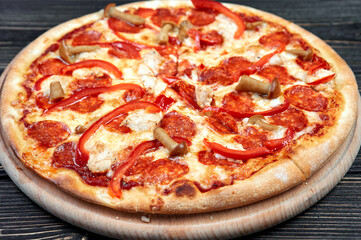 Hot tasty traditional italian pizza with salami, cheese, tomatoes greens