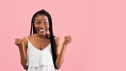 Positive black woman with afro bunches making YES gesture, feeling victorious on pink studio background, copy space