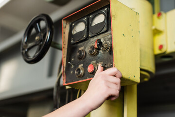 Cropped view of welder tuning welding machine in factory