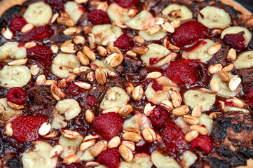 Sweet pizza with chocolate and fruits on black background