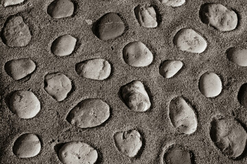Brown background of pebbles in concrete. Big pebbles in the concrete mixture. Texture of pebbles for poster, branding, calendar, card, banner, cover, space for your design or text. High quality photo