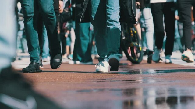 Legs of Crowd People Walking on the Street, Close-up of People feet. Slow Motion in 120fps. Many feet walk along the sidewalk. Low view of crowded people walking along the road in the park. City Crowd