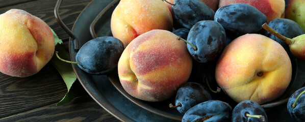 tray with fresh peaches and plums close-up