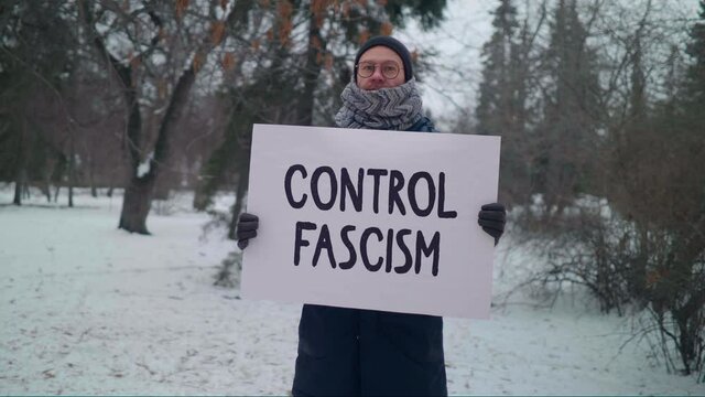 Man Wearing a Scarf is Holding a Placard Control Fascism. He is Standing Against the Paramilitary Forces Using Violence to Suppress Dissent. Against the Unjust Judgment of People of Different Races.