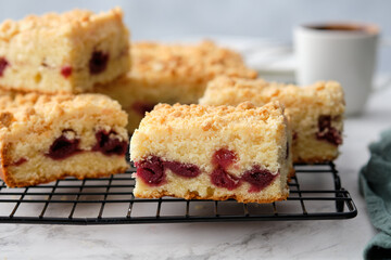 A stack of baked square pieces of cherry pie on a white background. Sour cream coffee cake with the...
