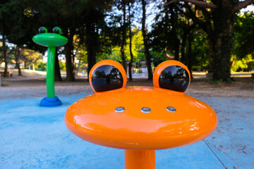 Metal orange frog fountain in the park. Holes for water on the nose of the frog. Modern fountains...