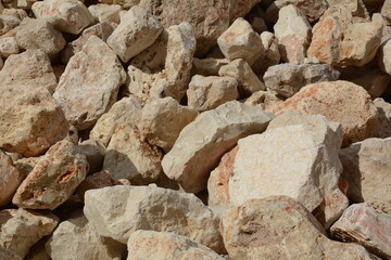 Photo of a large pile of stones at construction site, on the coastline of Mediterranean sea on calm day