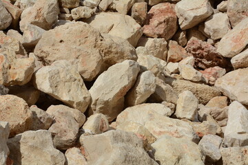 Photo of a large pile of stones at construction site, on the coastline of Mediterranean sea on calm day