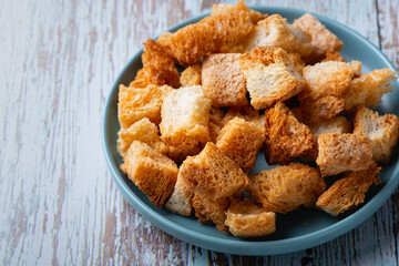 Fried croutons of bread on a blue wooden table