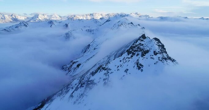 Aerial footage of Mount Siguniang Steep snow mountain peaks and white clouds floating The sea of clouds floats among the mountains At sunset in Sichuan China