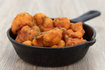 Spicy and breaded buffalo cauliflower nuggets to eat out of the cast iron pan as finger food