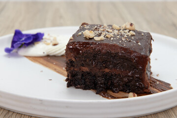 Sweet treat dessert for after dinner includes a rich piece of chocolate cake topped with crushed nuts