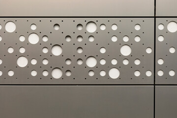 Round hole tiles. Metal cladding of the building facade