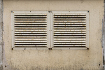 The ventilation grill is installed on a cement wall. grille for indoor climate control. ventilation...